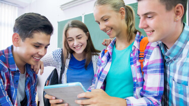 Gruppe Sch&uuml;ler:innen mit Tablet in Klasse
