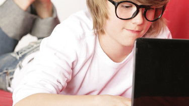 Ein Junge spielt am Laptop