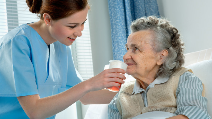 Pflegerin gibt älterer Dame zu trinken © Alexander Raths, stock.adobe.com