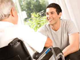 Mann im Rollstuhl spricht mit Berater