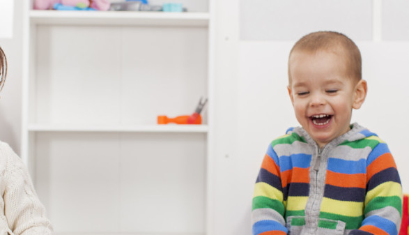 © Boggy, stock.adobe.com Zwei kleine Mädchen und ein Bub sitzen im Kindergarten und lachen © Boggy, stock.adobe.com