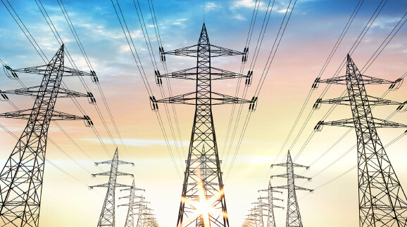 Drei Reihen von knapp hintereinander stehenden Strommasten, das Bild scheint KI zu sein