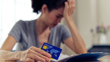Verzweifelte Frau mit Kreditkarte