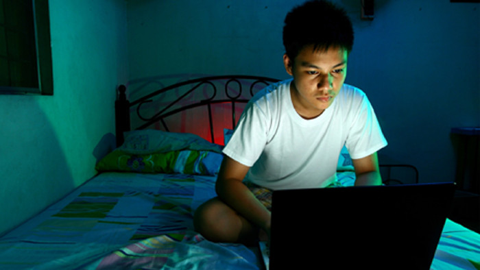 Jugendlicher mit Laptop auf dem Bett © Junpinzon, stock.adobe.com
