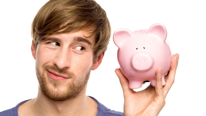 Mann mit einem Sparschwein in der Hand