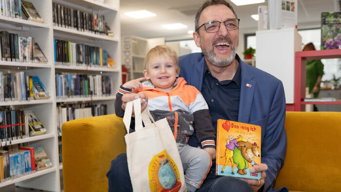 AK-Präsident Gerhard Michalitsch mit seinem Enkel Yuki, der die Buchstart-Tasche bereits zu Hause hat, in der AK-Bücherei in Eisenstadt.
