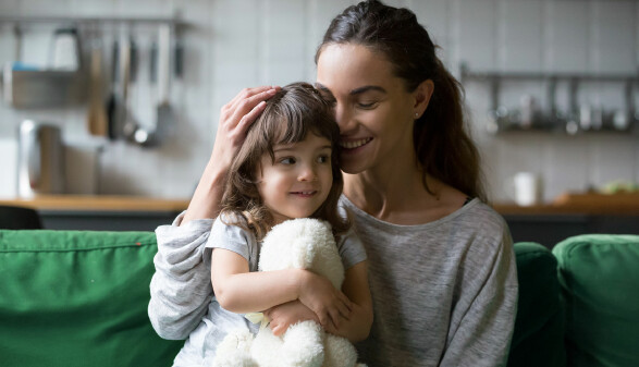 Alleinerziehende Mutter, die Tochter umarmt