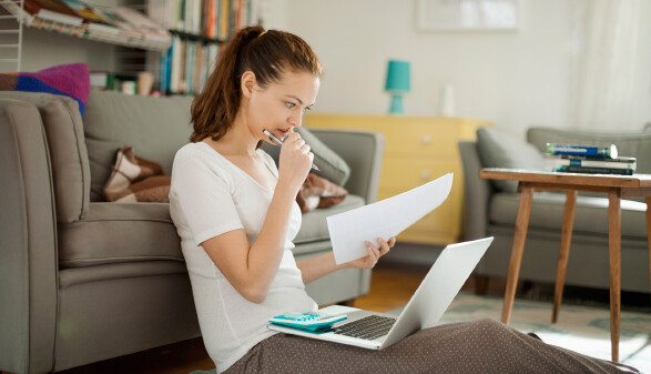 junge Frau betrachtet Rechnungen