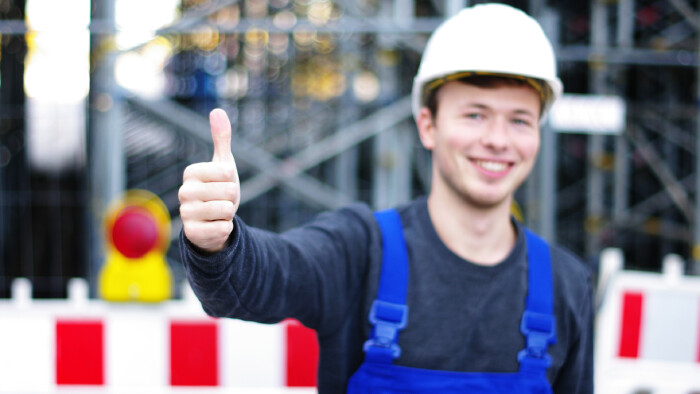 Junger Mann in Arbeitskleidung streckt Daumen in die Höhe © Wellnhofer Designs, stock.adobe.com Junger Mann in Arbeitskleidung streckt Daumen in die Höhe
