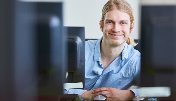 Junger Mann bildet sich mit Computerkurs fort