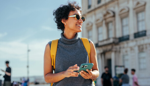 Junge Frau befindet sich im Urlaub und verwendet Handyroaming