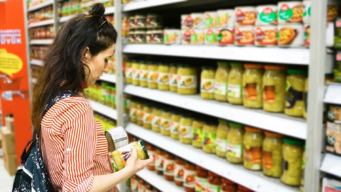 Frau steht vor Supermarkt-Regal